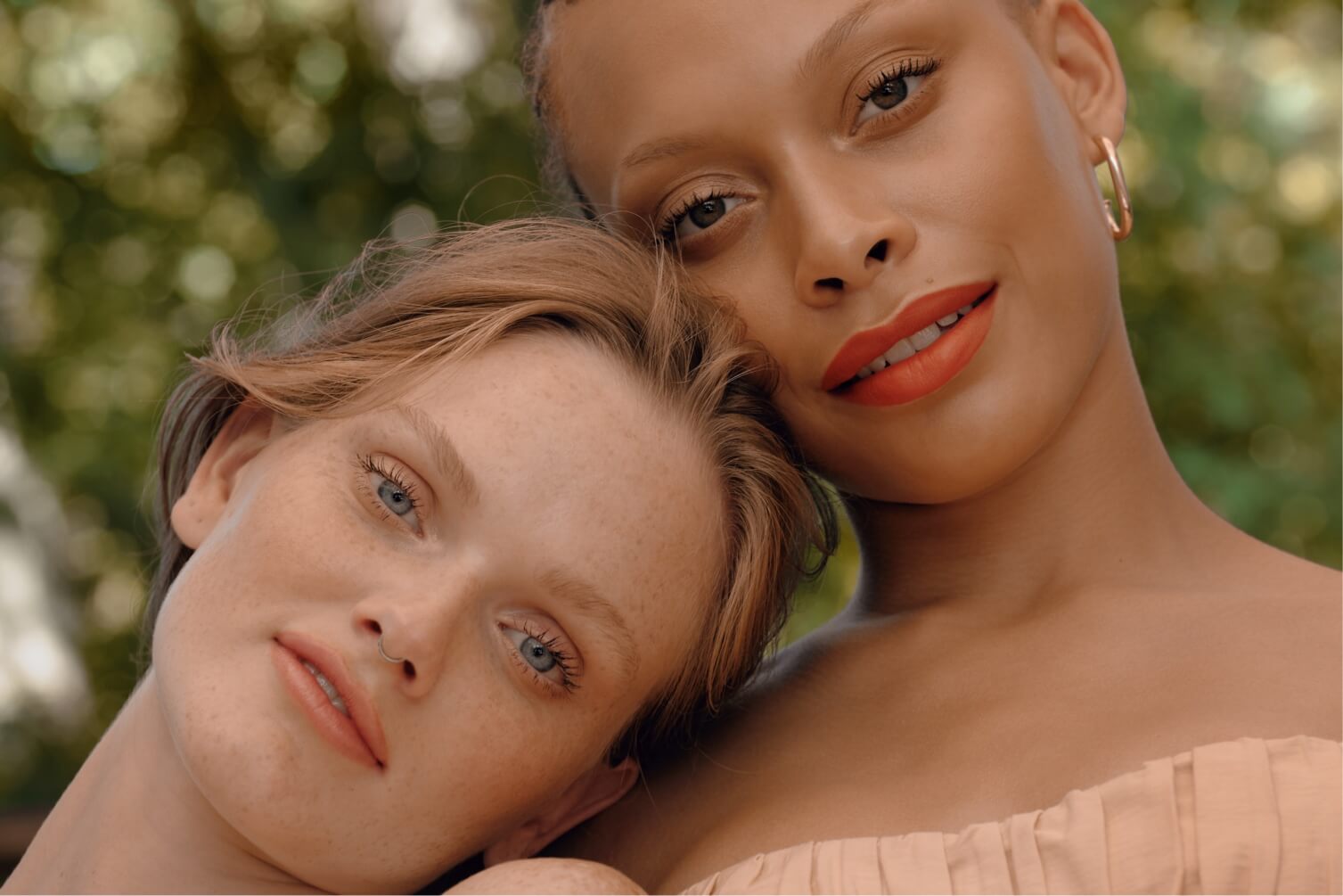 Two women leaning on each other and smiling